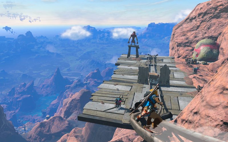 Link standing on a wooden platform above a red canyon